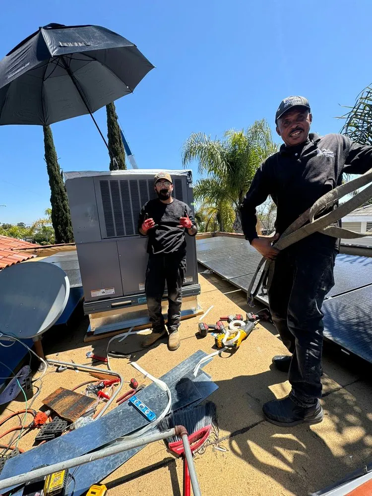 Technicians servicing a rooftop AC unit