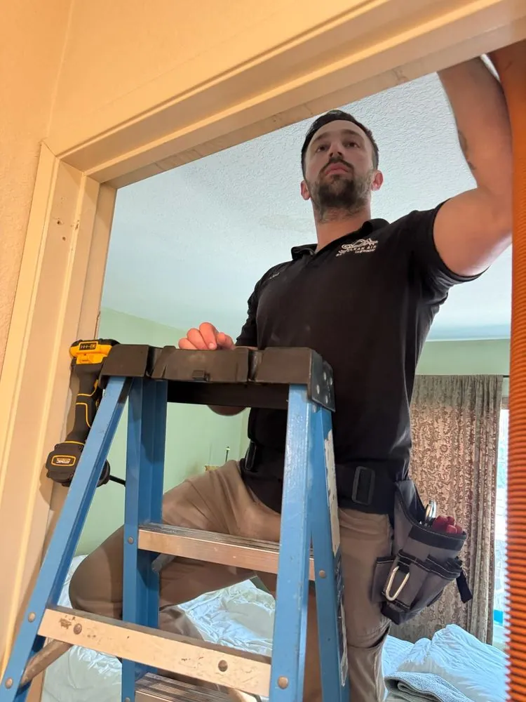 Technician working from a ladder inside a home