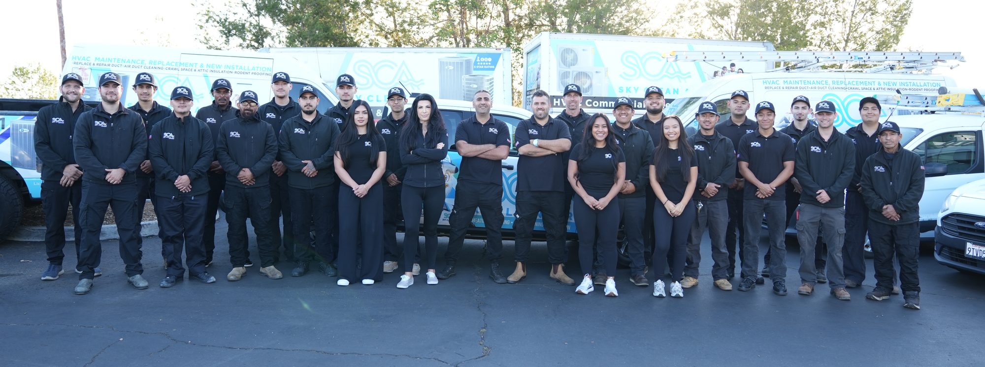 The full Sky Clean Air team lined up in front of their branded service vans